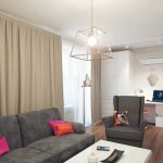 أريكة رمادية في داخل غرفة معيشة صغيرة