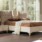 غرفة نوم أرستقراطية مع سرير مع لوح أمامي مرتفع ذو شكل غير عادي