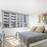 السرير في أسلوب بساطتها في الغرفة مع نوافذ على الجدارين