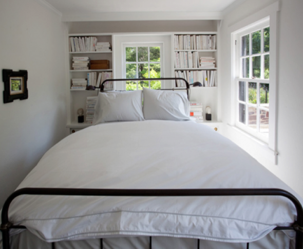 غرفة نوم ضيقة للبالغين مع خزائن حول النافذة