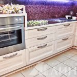 مطبخ زاوية بيضاء مع فرن على خزانة عالية