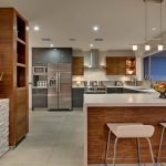 يجمع أثاث المطبخ بين الأبيض والجوز في الداخل.