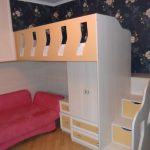 يوجد فوق الأريكة الحمراء للراحة النهارية: خزانة حائط وسرير علوي