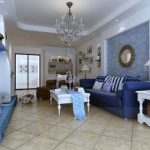 غرفة بيضاء وزرقاء مع أريكة زرقاء