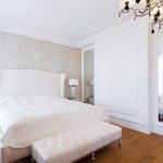 سرير أبيض ناصع مع ظهر عالٍ و baketka تبدو جيدة على لوح خشبي بلون الجوز