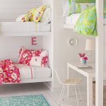 غرفة للأطفال مع ثلاثة أسرة مدمجة ومساحة للعمل