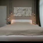 سرير أبيض ضخم مع حواف مدورة بجانب النافذة البانورامية