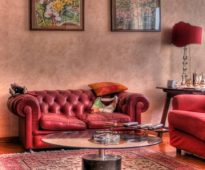 أريكة حمراء ضد جدار الطين