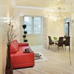 غرفة معيشة ومطبخ مع أريكة حمراء زاهية