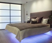 سرير ذو ظهر ناعم وأضواء أدناه