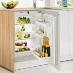 مطبخ صغير مع ثلاجة صغيرة تحت كونترتوب