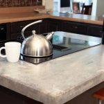 يمكن للأصباغ المحايدة وأحجار الأنهار أن تحول جزيرة المطبخ إلى قاع نهر جاف ناعم.