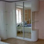 زاوية خزانة بيضاء مع صور على الزجاج والأرفف المفتوحة