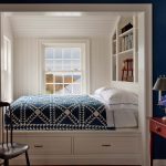 سرير في مكان قريب من النافذة مع رف مدمج للكتب