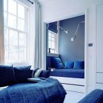 سرير في مكان مغلق في الغرفة باللون الأزرق والأبيض