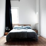 غرفة نوم بيضاء صغيرة مع سرير بجوار النافذة