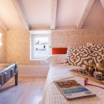 غرفة صغيرة ذات سقوف منخفضة مع أثاث مناسب.