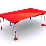 الطلاء الأحمر الساطع يقطر من سطح مستطيل ويعوم في الهواء.