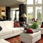 أريكة بيضاء وكراسي في غرفة المعيشة في منزل ريفي