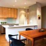 مطبخ خشبي مع أسطح طاولات حجرية وخزائن حتى السقف