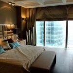 غرفة نوم أنيقة مع نافذة بانورامية وسرير كبير.