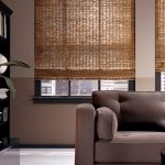 أريكة رمادية في غرفة المعيشة مع نافذتين