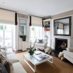 غرفة معيشة مع ستائر رومانية على نوافذ مثبتة على السقف