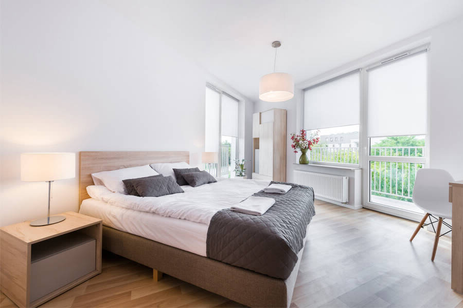 ستائر بيضاء بمحرك كهربائي على النافذة مع شرفة