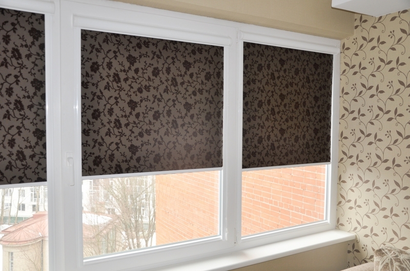 ستائر ملفوفة داكنة على نافذة لوجيا بلاستيكية