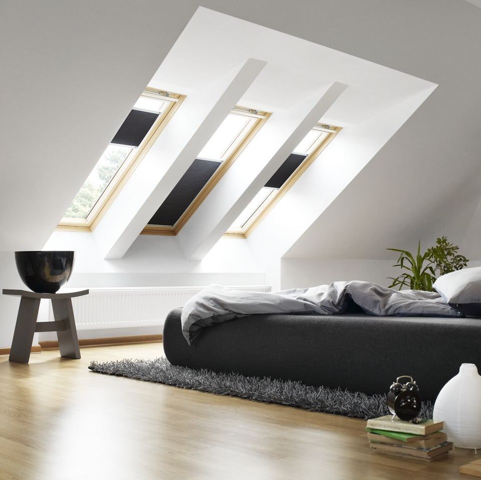 سرير أسود في غرفة علية بيضاء