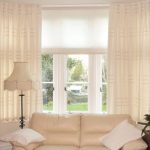 ستائر بيج فاتحة على النافذة في غرفة المعيشة