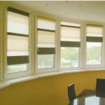 ستائر مخططة على النافذة المقوسة للوجيا الفسيحة