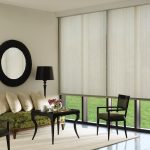 مرآة مستديرة كبيرة فوق الأريكة في غرفة المعيشة