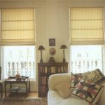 ستائر رومانية خفيفة على النوافذ العالية لغرفة المعيشة