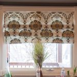 ستارة من القماش مع إبزيم على إطار النافذة